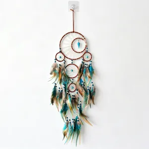 Detailed view of the multi-ring dream catcher with turquoise beads and feather pendants.