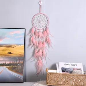 Detailansicht des rosa Traumfängers als Hängeornament mit Federn und Perlen für Wanddekoration.
