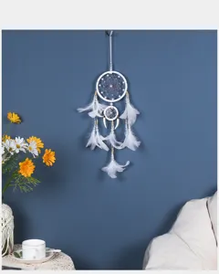 Detalle del atrapasueños de plumas blancas, elegante decoracion de pared para el hogar.
