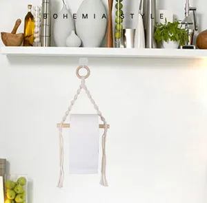 Handmade bohemian macrame toilet paper holder with wooden ring and rod for bathroom storage.