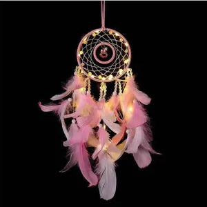 Pink dream catcher detail shot featuring delicate feathers, warm LED fairy lights, and cute charm.