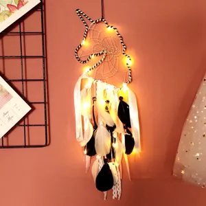 Detailed shot of the unicorn dream catcher wall hanging with glowing LED lights and soft feathers.