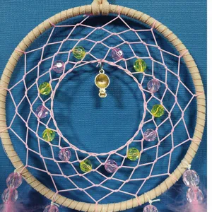 Handmade pink dream catcher with colorful beads and hot air balloon pendant for cute room decor.