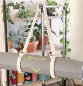 Handmade cotton rope yoga mat carrying strap with wooden rings, stylish woven sling for easy transport.