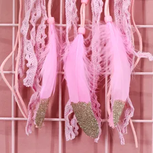 Detailed view of the pink dream catcher featuring glitter feathers, lace ribbons and beads.