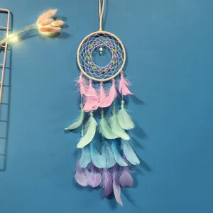 Close-up of a colorful pastel feather dream catcher with delicate beads and unicorn pendant.