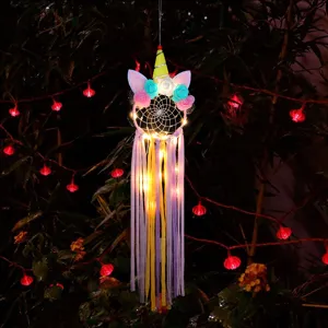 Unicorn dream catcher night light with LED string lights and tassels for room decor.