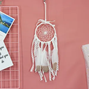 White handmade dream catcher with lace ribbons and feathers for wall decor and gifts.