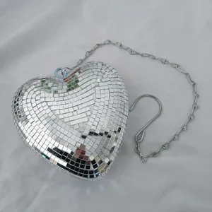 Close-up view of a heart-shaped disco ball ornament with a silver chain and hanging hook.