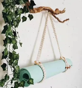 Handmade macrame yoga mat strap detail, natural cotton rope hanger for wall storage.