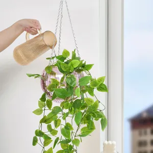 Pink disco ball hanging planter with chains and artificial green ivy vines for home decor.