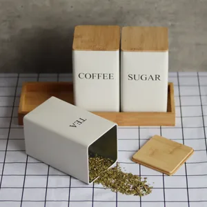 Metal kitchen storage canisters set with bamboo lids and wooden tray for coffee sugar tea.