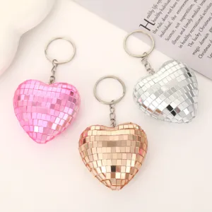 Heart-shaped disco ball keychains featuring reflective mirror glass design in pink, gold, and silver.