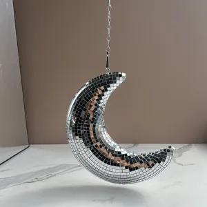 Gros plan détail de boule disco lune suspendue avec des carreaux de mosaïque et chaîne.