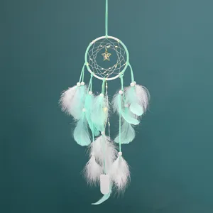 Attrape-rêves en plumes vert menthe avec guirlande LED et pendentif étoile pour décoration murale.