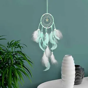 Attrape-rêves vert menthe mural avec plumes perles pour décoration de chambre maison vue de détail.