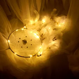 Warm LED dreamcatcher string lights with feathers and beads for holiday decor and bedroom ambience.