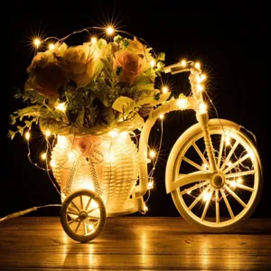 Detailed view of a charming white bicycle flower basket decorated with warm LED fairy lights.