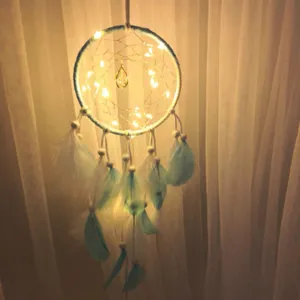 Attrape-rêves lumineux avec plumes bleues et guirlande LED pour décoration murale détail.