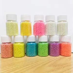 Glow in the dark sand particles in small transparent bottles, detail shot for DIY crafts.