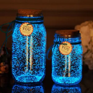 Glow in the dark luminous sand glass jars detail view showing bright blue glowing effect.