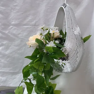 Gedetailleerde weergave van een discobal hangpot met kunstmatige witte bloemen en groene ranken.