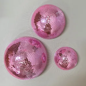 Gedetailleerde close-up van roze disko-spiegelbollen met glanzende mozaïektegeltjes.