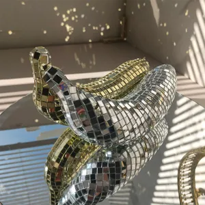 Primo piano di ornamento da tavolo banana specchio disco creativo, decoro mosaico riflettente.