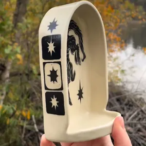 Handheld detail view of the resin saintly niche altar ornament, featuring unique star motifs.