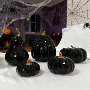 Detailed close-up shot of black mosaic glass pumpkin decor with gold stem for Halloween.