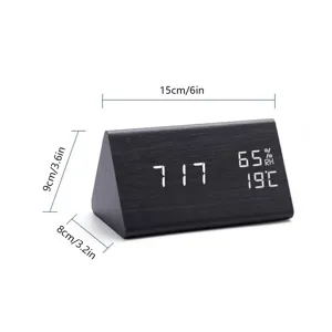Wooden digital LED alarm clock detail, triangular design showing time, temperature, and humidity.