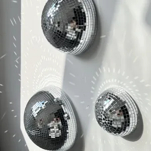 Nahaufnahme von halben Spiegelkugeln an der Wand mit schönen Lichtreflexionen.