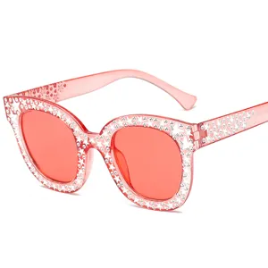 Große quadratische Sonnenbrille mit funkelnden Strasssteinen und Sternen, rosa Gestell.