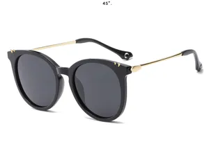 Vue détaillée de lunettes de soleil polarisées noires élégantes avec branches dorées et rivets.