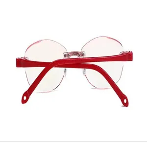 Close-up detail of women's rimless reading glasses with red glitter temples and cut lenses.