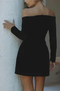 Robe courte noire en velours à épaules dénudées et manches longues avec strass brillants.