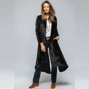 Detailed view of the black velvet texture, elegant long cut and fine fabric drape.