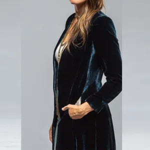 Close-up detail of women's dark velvet long coat with gold chain accessory stylish