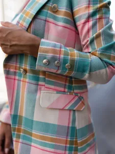 Exquisite detail view of women's colorful plaid blazer jacket featuring elegant metallic buttons.