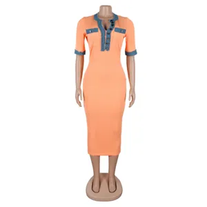 Close-up detail of the orange bodycon dress featuring stylish denim patchwork trim and V-neck.