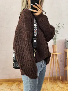 Vista detallada del cárdigan suéter de punto grueso vintage para mujer en marrón con bolso elegante.