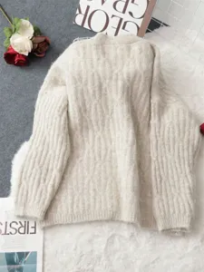 Primer plano detalle jersey de punto beige, textura suave y cálida, estilo plano acogedor.