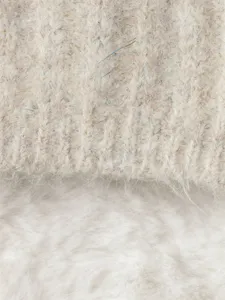 Primer plano del tejido de jersey de punto grueso para mujer con textura suave y brillos.
