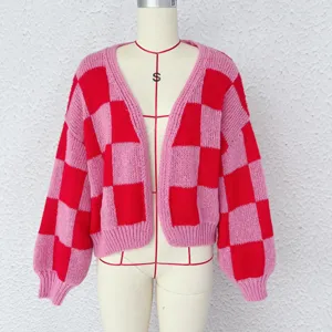 Vue détaillée du cardigan en tricot à carreaux rose et rouge, col V et manches bouffantes.