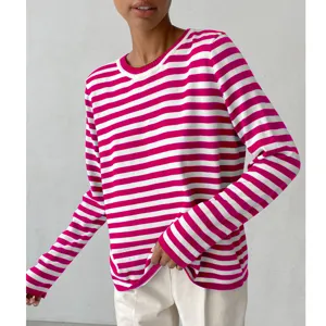 Close-up detail of women's pink and white striped knit sweater, casual round neck long sleeve.