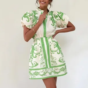 Chic green and white printed two piece set featuring a short sleeve blouse and matching mini skirt.