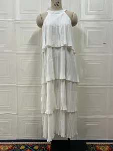 Detalle del vestido largo blanco sin mangas plisado halter, estilo elegante con volantes en cascada.
