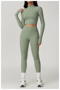 Completo sportivo a costine verde salvia con top corto con zip e leggings a vita alta.
