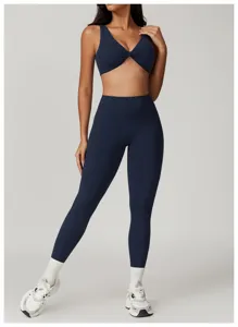 Dettaglio set yoga blu navy, reggiseno sportivo con torsione frontale e leggings a vita alta.