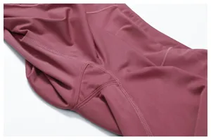 Dettaglio pantaloni yoga sportivi da donna, tessuto fitness traspirante ed elastico.
